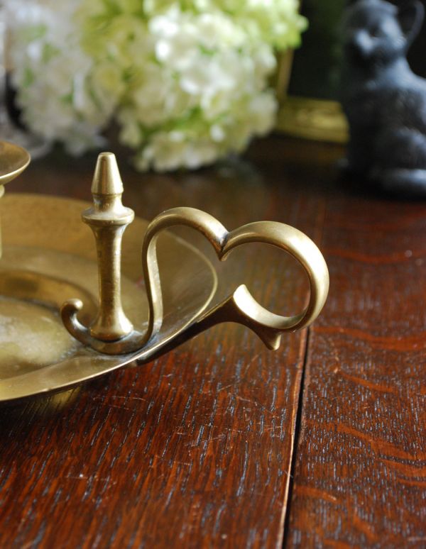 シルバーのテーブルウェア　アンティーク雑貨　イギリスアンティークの雑貨、持ち手付き真鍮製キャンドルスタンド。真鍮製なので、使っていくごとに味わい深い色合いに変化していきます。(d-1270-z)