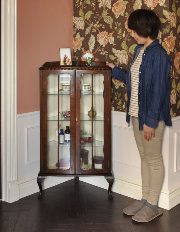 アンティークのキャビネット　アンティーク家具　小ぶりなアンティークの英国家具、コーナーガラスキャビネット。お部屋の角にすっぽり収まる飾り棚！コーナーのオシャレにいかが？（モデルの身長は163cmです）【 全体 】幅67.5×奥行46×高さ119.5cm。(j-1270-f)