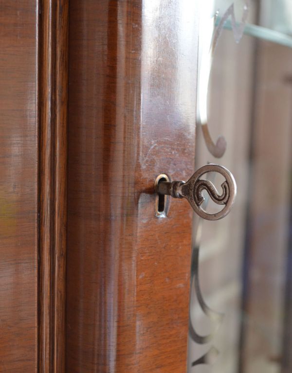 アンティークのキャビネット　アンティーク家具　英国アンティーク家具、扉の飾りがキレイなガラスキャビネット。鍵穴が付いています。(j-1275-f)