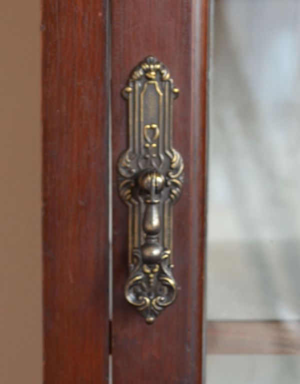 アンティークのキャビネット　アンティーク家具　マホガニー材で造られたアンティーク英国家具、ガラス扉のブックケース（本棚）。アンティークならではの重厚感のある取っ手です。(j-1372-f)