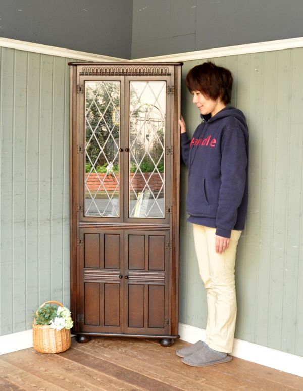 アンティーク家具　シックなアンティークの英国家具、コーナーガラスキャビネット。お部屋の角にすっぽり収まる飾り棚！コーナーのオシャレにいかが？（モデルの身長は163cmです）【 全体 】幅68×奥行35.5×高さ167cm。(j-1430-f)