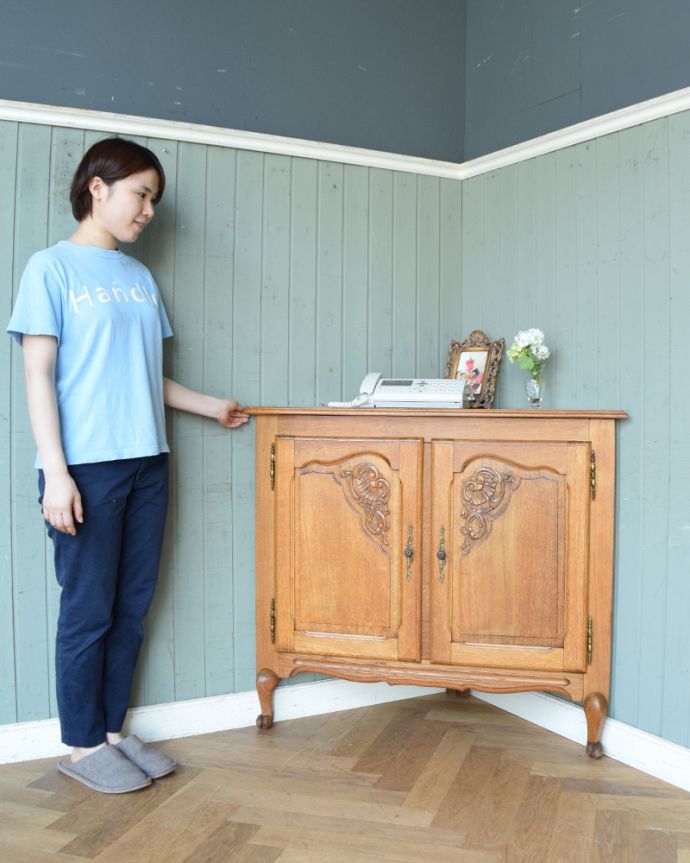 アンティークのキャビネット　アンティーク家具　優雅な彫りのアンティーク家具、小ぶりなフレンチコーナーキャビネット。お部屋の角にすっぽり収まる飾り棚！コーナーのオシャレにいかが？（モデルの身長は158cmです）。(j-1749-f)