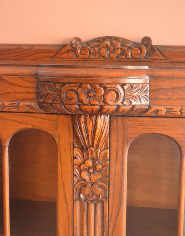 アンティークのキャビネット　アンティーク家具　お花が華やかなアンティークの英国家具、鍵付きのブックケース（本棚）。キャビネットの真ん中に存在感たっぷりの彫りです。(k-1072-f)
