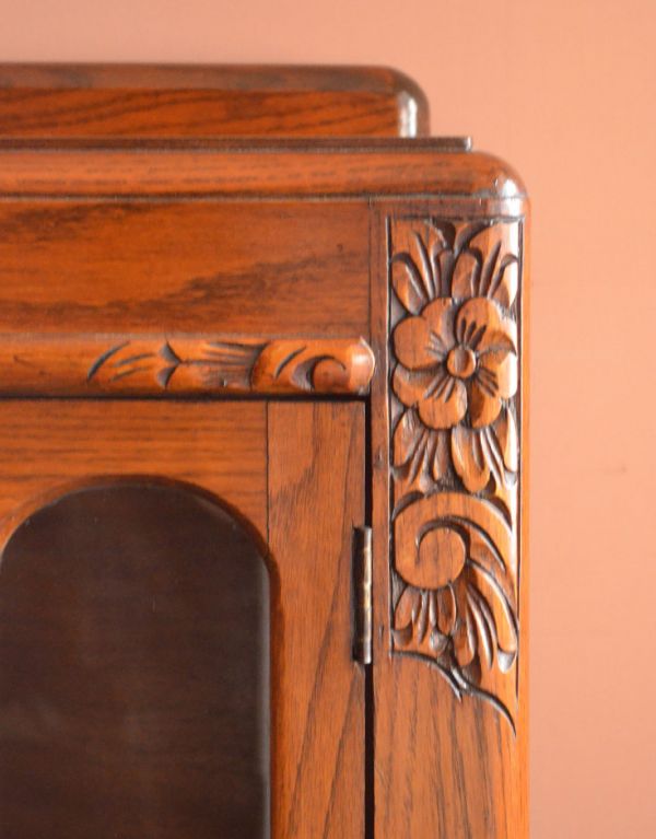 アンティークのキャビネット　アンティーク家具　お花が華やかなアンティークの英国家具、鍵付きのブックケース（本棚）。角にも中央とお揃いのお花の彫です。(k-1072-f)