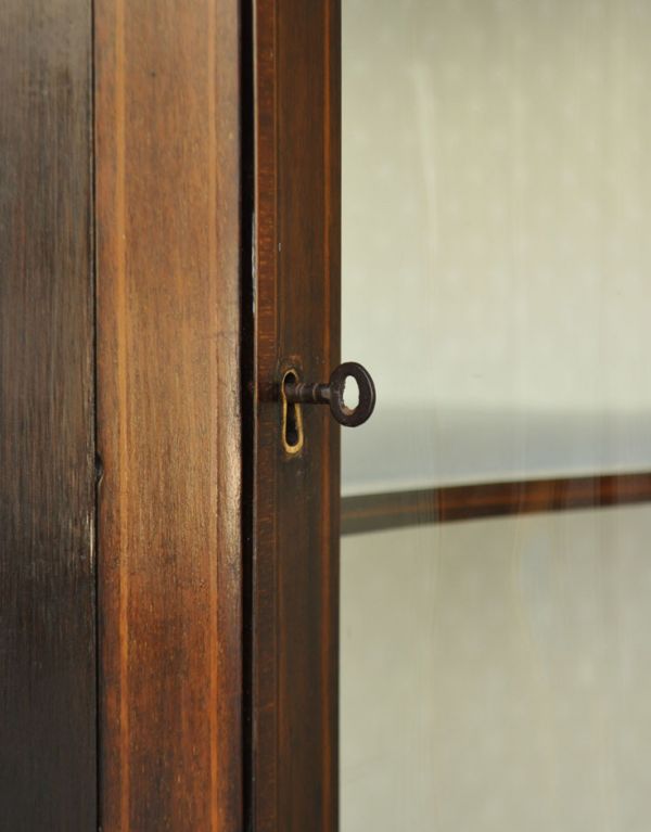 アンティークのキャビネット　アンティーク家具　角を有効に使うアンティーク家具、ガラス扉のコーナーキャビネット。扉は、鍵が取っ手となります。(k-1135k-f)