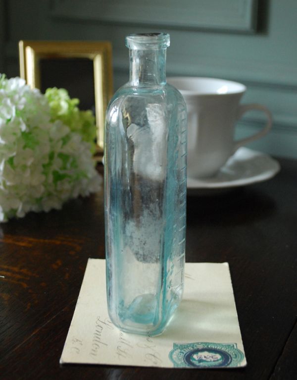 ナチュラルカントリースタイル　アンティーク雑貨　目盛り付き、アイスブルーのアンティークガラスボトル。ミルクや薬品、調味料など様々な用途で使われてきたアンティークボトルたちです。(k-1246-z)
