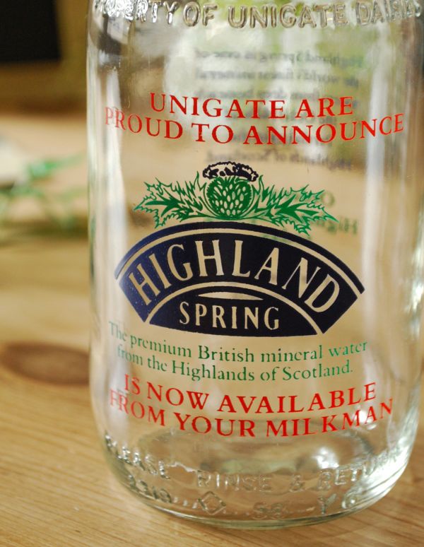 ナチュラルカントリースタイル　アンティーク雑貨　イラスト入りで可愛いイギリスの牛乳ビン、アンティークガラスボトル（スプリング）。海外らしいおしゃれなフォントが入っています。(k-1360-z)