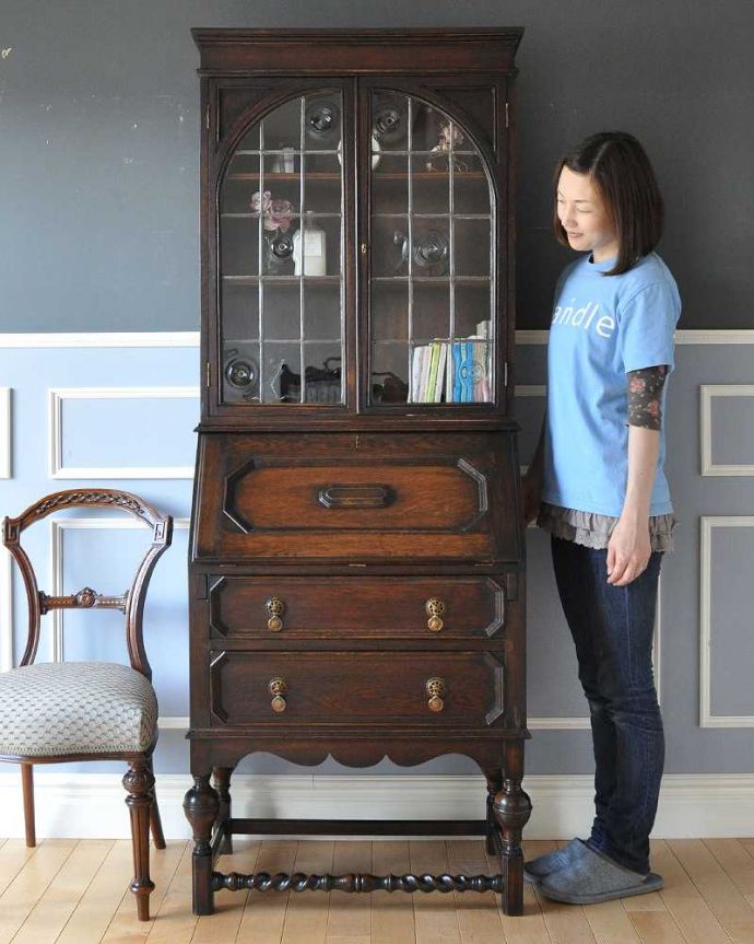 ビューロー アンティーク家具 珍しいロンデルガラスが使われたビューローブックケース、英国輸入のアンティーク収納家具。飾り棚とパソコンスペース、両方欲しい方にオススメなのが、このブックケースビューロー!(モデルの身長は165cmです)。(k-1463-f)