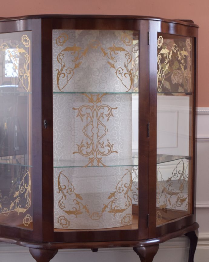 アンティークのキャビネット アンティーク家具 ウォルナット材のアンティーク家具、ガラスの装飾も美しいミラー付きガラスキャビネット。庫内の背板は、中央がクロスで両サイドはなんとミラーが貼られています。(k-1464-f)