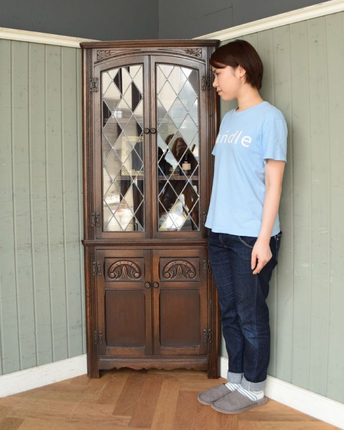 アンティークのキャビネット アンティーク家具 お部屋の角を彩るアンティーク家具、ガラス扉のコーナーキャビネット。お部屋の角にすっぽり収まる飾り棚!コーナーのオシャレにいかが?(モデルの身長は158cmです)。(k-1500-f)