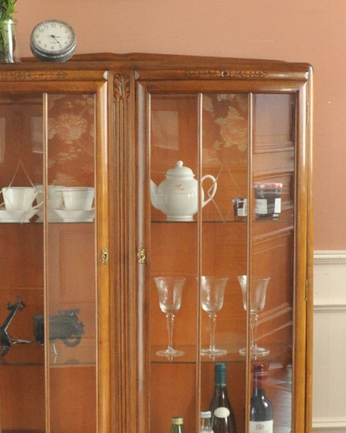 アンティークのキャビネット　アンティーク家具　イギリスのキレイなアンティーク家具、お花の彫りが刻まれた明るい色のガラスキャビネット。幅が広くて、存在感と迫力があります。(k-1502-f)