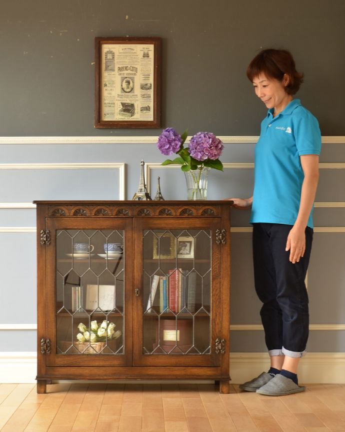 アンティークのキャビネット アンティーク家具 飾り棚にもなるアンティークの英国家具、お花の彫りが沢山付いたオーク材ブックケース(本棚)。本棚としてはもちろん、グラスや食器を並べて飾り棚としても素敵ですよ。(k-1530-f)