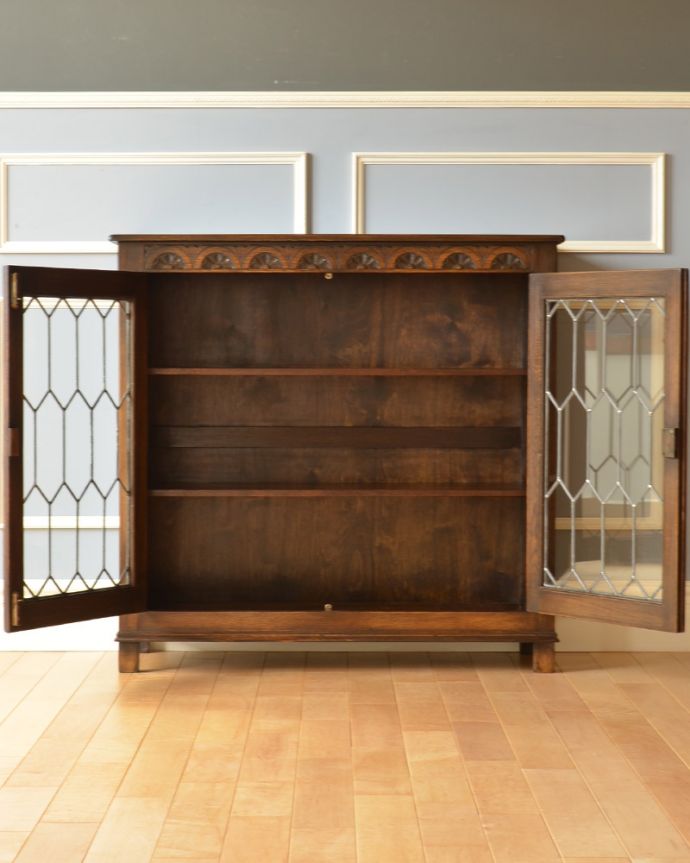 アンティークのキャビネット アンティーク家具 飾り棚にもなるアンティークの英国家具、お花の彫りが沢山付いたオーク材ブックケース(本棚)。両開きで出し入れもしやすいですよ。(k-1530-f)