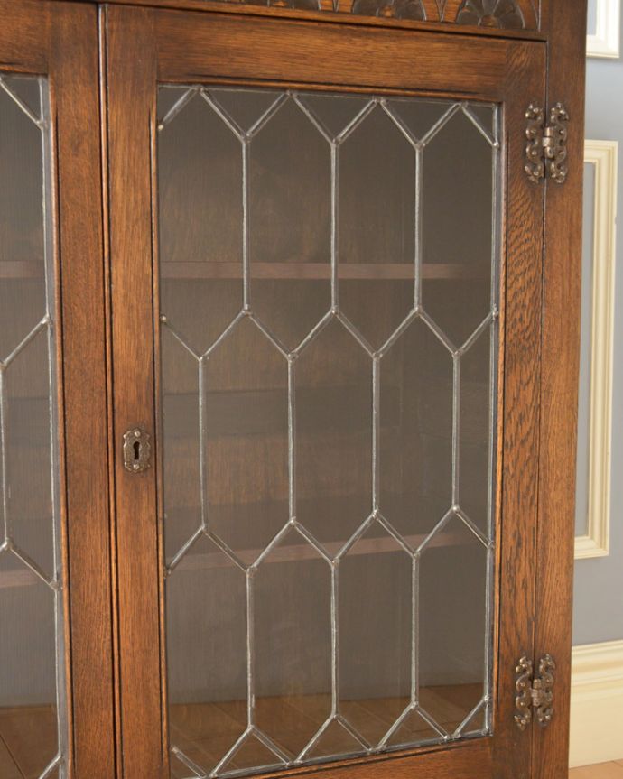 アンティークのキャビネット アンティーク家具 飾り棚にもなるアンティークの英国家具、お花の彫りが沢山付いたオーク材ブックケース(本棚)。ガラスももちろん当時のもの。(k-1530-f)