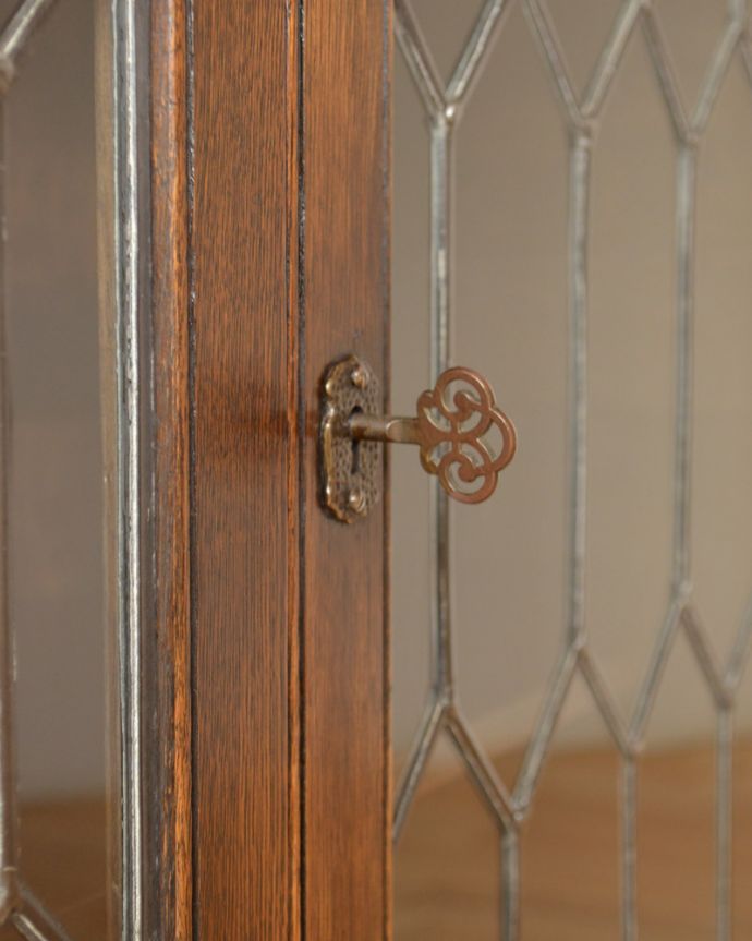 アンティークのキャビネット アンティーク家具 飾り棚にもなるアンティークの英国家具、お花の彫りが沢山付いたオーク材ブックケース(本棚)。アンティークの味わいが詰まっている小さな取っ手が付いています。(k-1530-f)