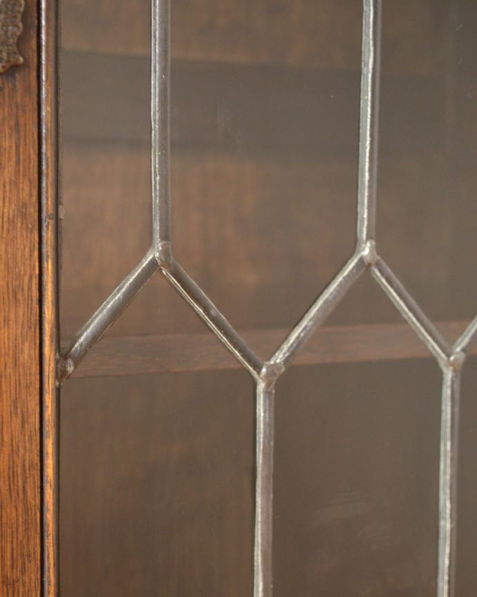 アンティークのキャビネット アンティーク家具 飾り棚にもなるアンティークの英国家具、お花の彫りが沢山付いたオーク材ブックケース(本棚)。ケイムで仕上げたお洒落なガラスです。(k-1530-f)