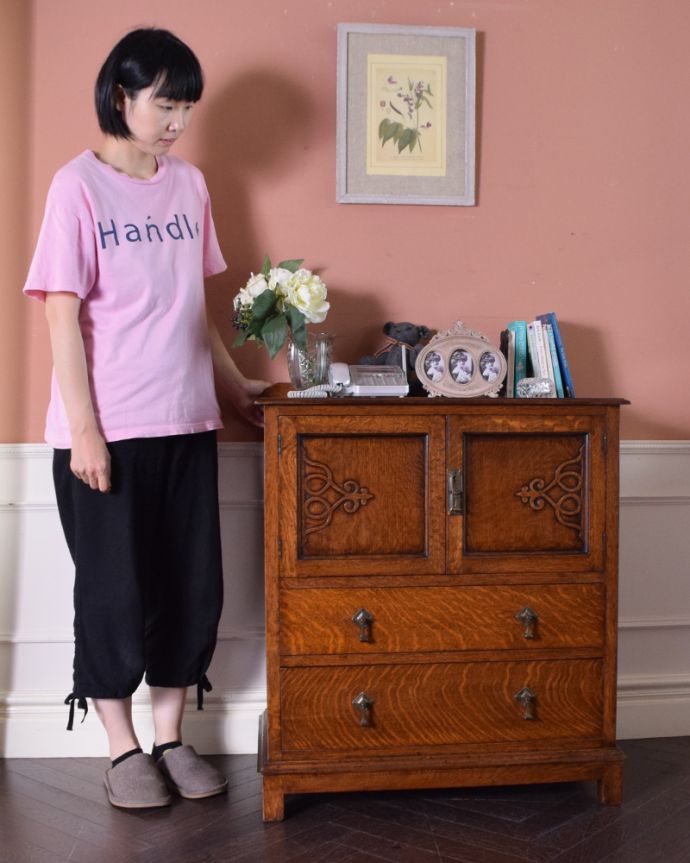 アンティークのチェスト アンティーク家具 イギリスのオシャレなアンティーク家具、扉の彫りがお洒落なカップボードチェスト(オーク材)。中が見えないので、生活感が出てしまう細々した物をたっぷり収納するのにピッタリです!(モデルの身長は161cmです)。(k-1554-f)