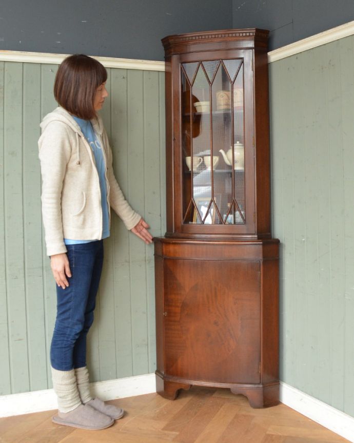 アンティークのキャビネット　アンティーク家具　英国輸入のアンティーク家具、マホガニー材のコーナーキャビネット。お部屋の角にすっぽり収まる飾り棚！コーナーのオシャレにいかが？（モデルの身長は165cmです）。(k-1556-f)