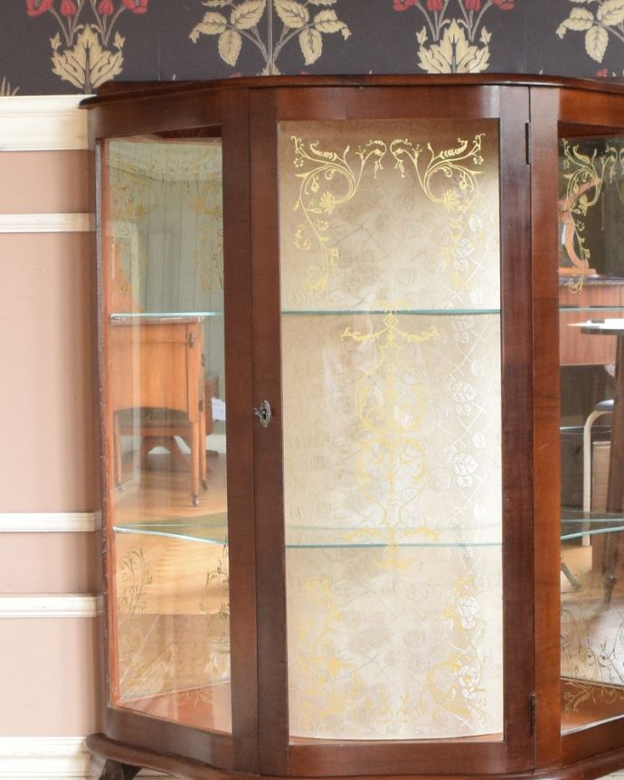 アンティークのキャビネット アンティーク家具 ゴールドの美しい模様を描いた扉付きのアンティークガラスキャビネット(飾り棚)。庫内の背板は、中央がクロスで両サイドはなんとミラーが貼られています。(k-1622-f)