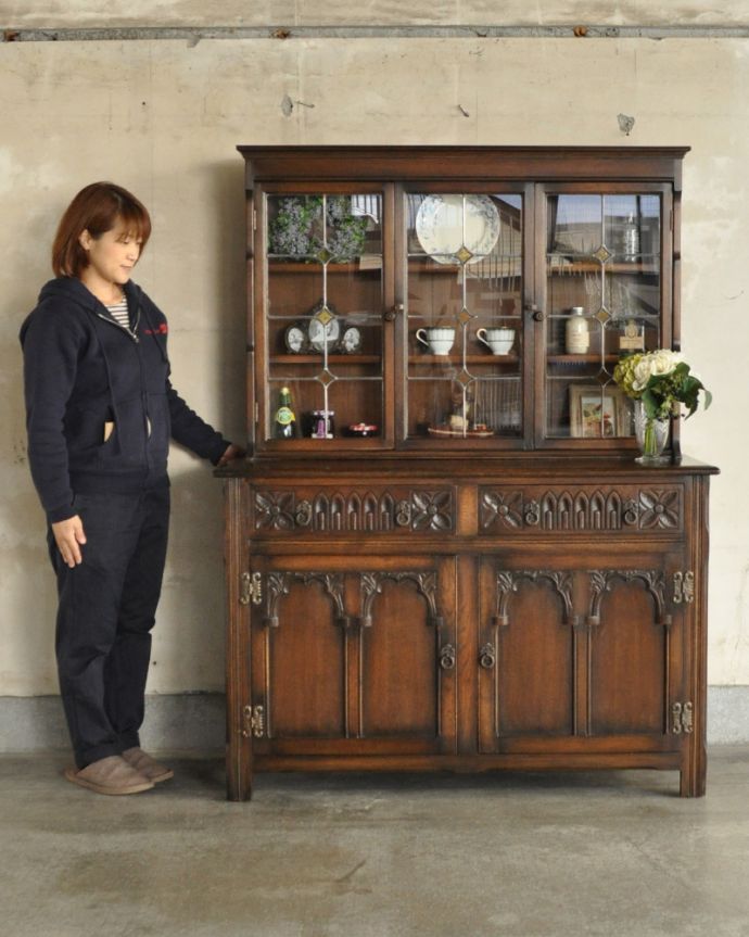 アンティークのキャビネット　アンティーク家具　ステンドグラス入りのアンティーク英国家具、お花の彫りが美しいカップボード。本棚としてはもちろん、グラスや食器を並べて飾り棚としても素敵ですよ。(k-1657-f)