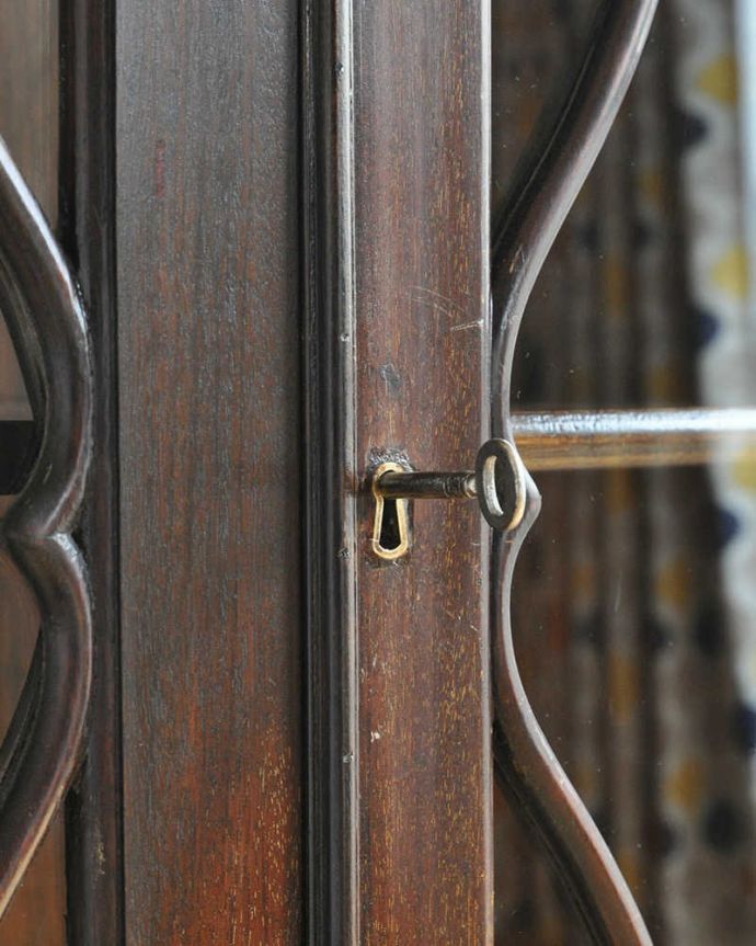 アンティークのキャビネット　アンティーク家具　曲線で描かれたガラス扉のデザインが美しいアンティーク家具、高級なマホガニー材を使ったガラスキャビネット。鍵を引っ掛けて取っ手のようにして開閉してください。(k-1703-f)