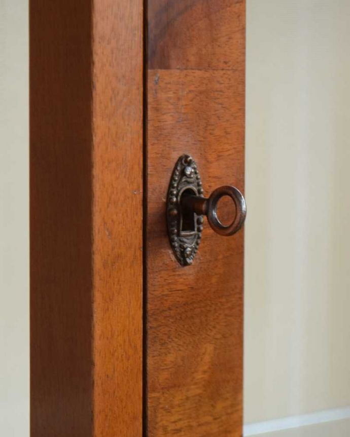 アンティークのキャビネット アンティーク家具 シンプルな美しさが際立つ、ウォルナット材のアンティークガラスキャビネット。開ける度にワクワクアンティークらしくカギが取っ手代わりについています。(k-1772-f)