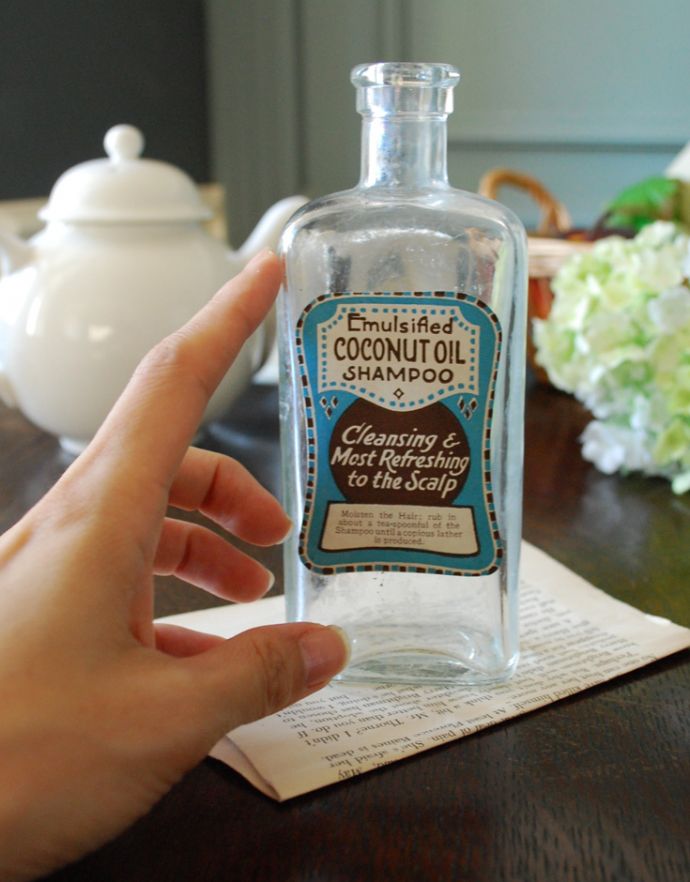 ナチュラルカントリースタイル　アンティーク雑貨　ステッカー付きアンティークガラスボトル（COCONUT OIL SHAMPOO）。１輪挿しにもピッタリです。(m-1488-z)