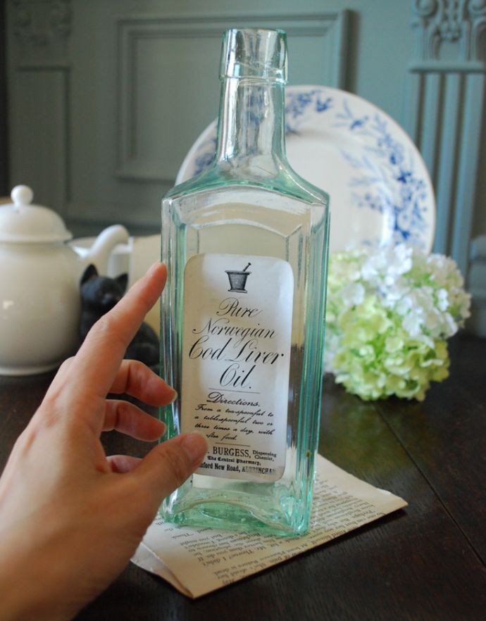 ナチュラルカントリースタイル　アンティーク雑貨　ステッカー付きアンティークガラスボトル(Pure Norwegian Cod Liver Oil)。ミルクや薬品、調味料など様々な用途で使われてきたアンティークボトルたちです。(m-1493-z)