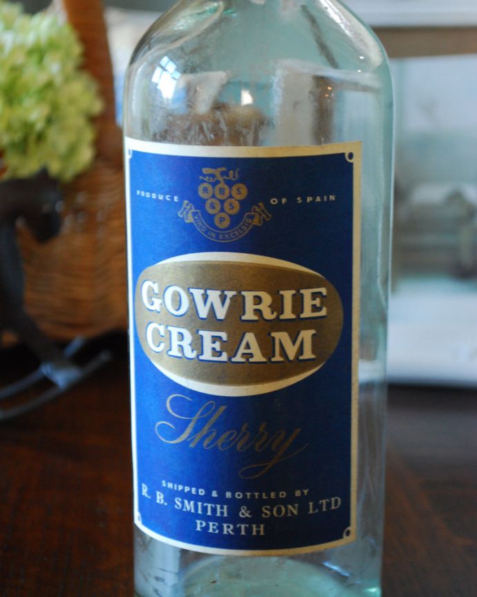 アンティーク ガラスボトル　アンティーク雑貨　ブルーのステッカー付きアンティークガラスボトル（GOWRIE CREAM）。厚みのあるガラスは、光が差し込むとこんなにもキラキラと美しいんです！ぜひ、窓辺で楽しんでいただきたいですね。(m-1601-z)