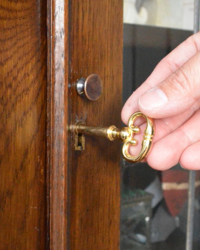 アンティークのキャビネット　アンティーク家具　ステンドグラスを嵌め込んだ英国のアンティークブックケース（本棚）。アンティークの味わいが詰まっている真ん丸な取っ手が付いています。(m-424-f)