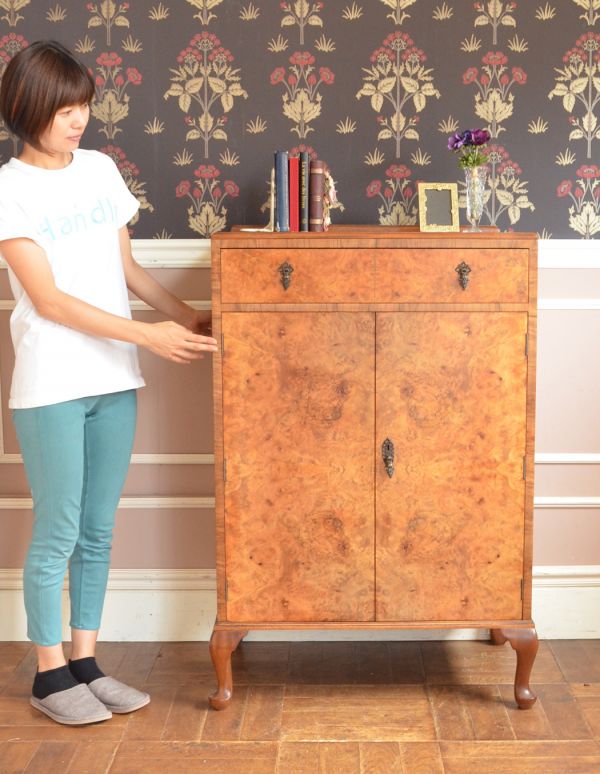 アンティークのキャビネット アンティーク家具 木目がキレイなアンティークの家具、イギリスの引き出し付トールボーイ(カップボードチェスト)。中が見えないので、生活感が出てしまう細々した物をたっぷり収納するのにピッタリです!(モデルの身長は160cmです)【 全体 】幅76.5×奥行52×高さ117cm。(m-487-f)