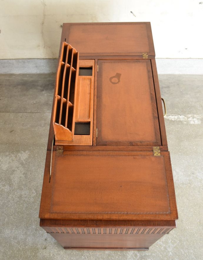 アンティークのデスク・書斎机 アンティーク家具 英国で見つけた機能的にも優れたライティングデスク、アンティーク英国家具(机)。中央の天板を開くと、棚が出てきて、革張りのライティングデスクに変わります。(m-540-f)