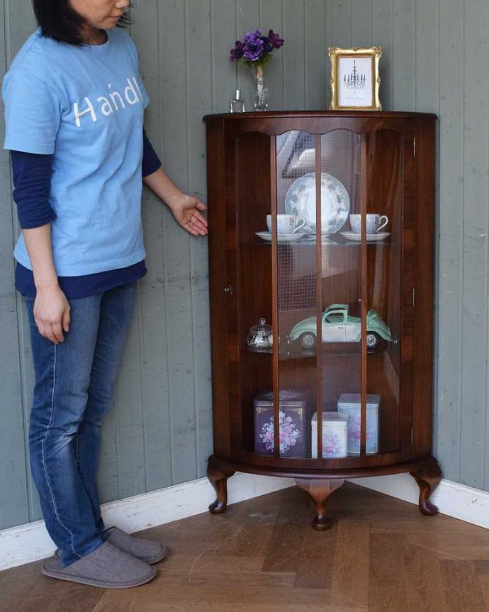 アンティークのキャビネット　アンティーク家具　英国輸入のアンティーク家具、木の装飾が上品なコーナーガラスキャビネット。お気に入りの雑貨や食器を並べてみましょう。(m-609-f)