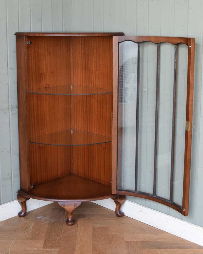 アンティークのキャビネット　アンティーク家具　英国輸入のアンティーク家具、木の装飾が上品なコーナーガラスキャビネット。３段あります。(m-609-f)