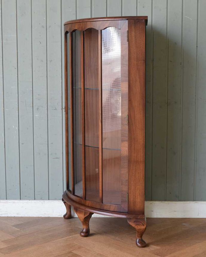 アンティークのキャビネット　アンティーク家具　英国輸入のアンティーク家具、木の装飾が上品なコーナーガラスキャビネット。丈夫に作られているので、長くお使いいただけます。(m-609-f)