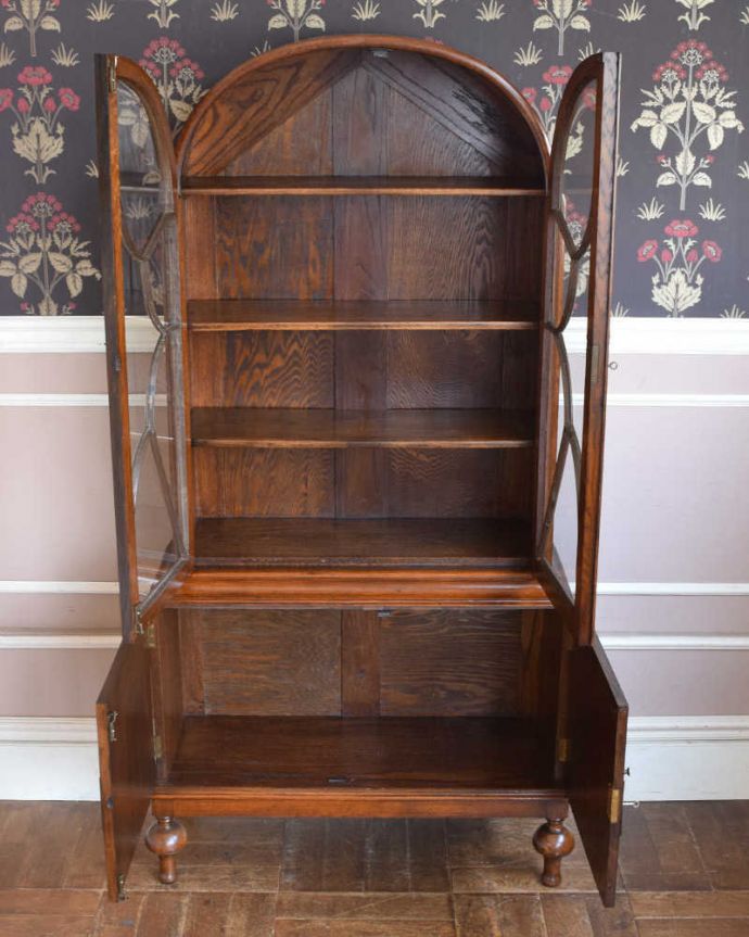 アンティークのキャビネット アンティーク家具 技術が光る美しいアーチ、英国アンティーク家具のガラスキャビネット(ブックケース)。扉の中は、しっかりと収納できる棚板重いものもたっぷり収納できる木製の棚板タイプ。(q-1162-f)