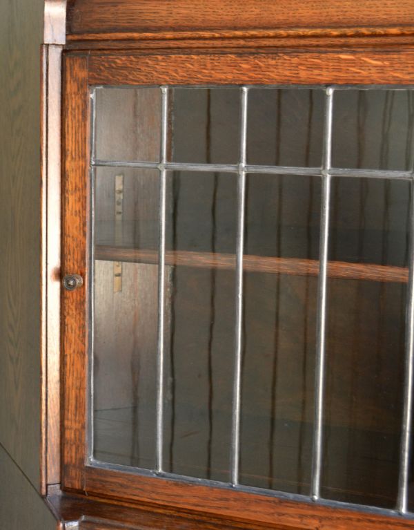 アンティーク家具　お部屋の角に置くアンティーク家具、コーナーガラスキャビネット。細いケイムの装飾が上品なアクセントになっています。(q-424-f)