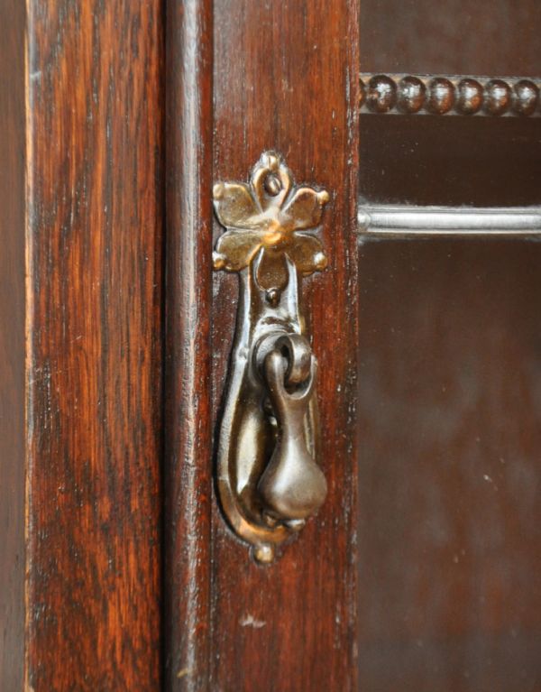 アンティークのキャビネット　アンティーク家具　ステンドグラス入りのコンパクトなアンティークガラスキャビネット。アンティークならではの凝った形の取っ手です。(q-443-f)