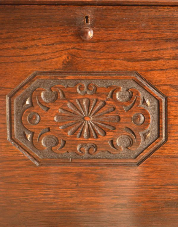 アンティーク家具 おしゃれなアンティーク英国家具、小ぶりなスチューデントビューロー。ビューロー扉のセンターに刻まれた装飾。(q-457-f)