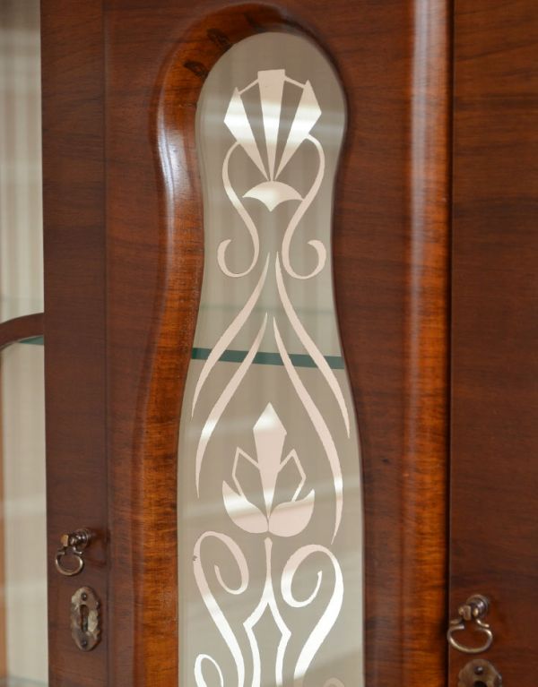 アンティークのキャビネット　アンティーク家具　扉の装飾が輝くアンティーク家具、英国のガラスキャビネット（ショーケース）。中央にはポイントになる華やかな装飾です。(q-494-f)