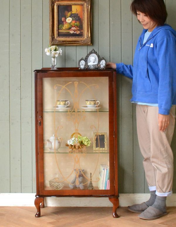 アンティークのキャビネット アンティーク家具 英国アンティーク家具、扉の飾りがキレイなガラスキャビネット(飾り棚)。ショーケースのように、お気に入りの雑貨や食器を並べてみましょう。(q-557-f)