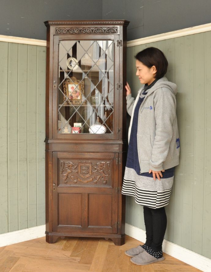 アンティークのキャビネット　アンティーク家具　お部屋の角を彩るアンティーク家具、ガラス扉のコーナーキャビネット。お部屋の角にすっぽり収まる飾り棚！コーナーのオシャレにいかが？（モデルの身長は158cmです）。(q-605-f)