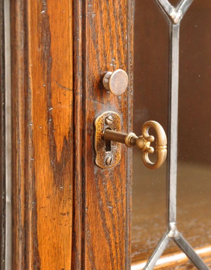 アンティークのキャビネット　アンティーク家具　英国から届いたアンティーク家具、ガラス扉のデザインが美しい木製のブックケース（本棚）。アンティークの味わいが詰まっている小さな取っ手が付いています。(q-675-f)