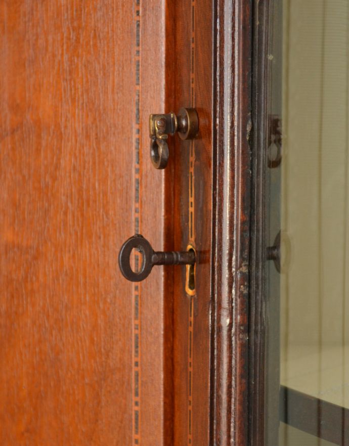 アンティークのキャビネット　アンティーク家具　角を有効に使うアンティーク家具、ガラスの曲線が美しいマホガニー材のコーナーキャビネット。扉には鍵がついています。(q-716-f)