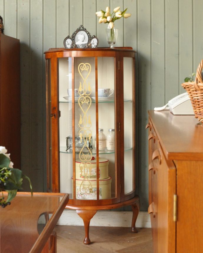 アンティークのキャビネット　アンティーク家具　ゴールドのハートの模様が入ったコンパクとなガラスキャビネット、英国アンティーク家具。お部屋をパッと彩ってくれる優秀キャビネットガラスのキャビネットがお部屋にあるだけで、パッと明るくなっちゃうんです。(q-835-f)