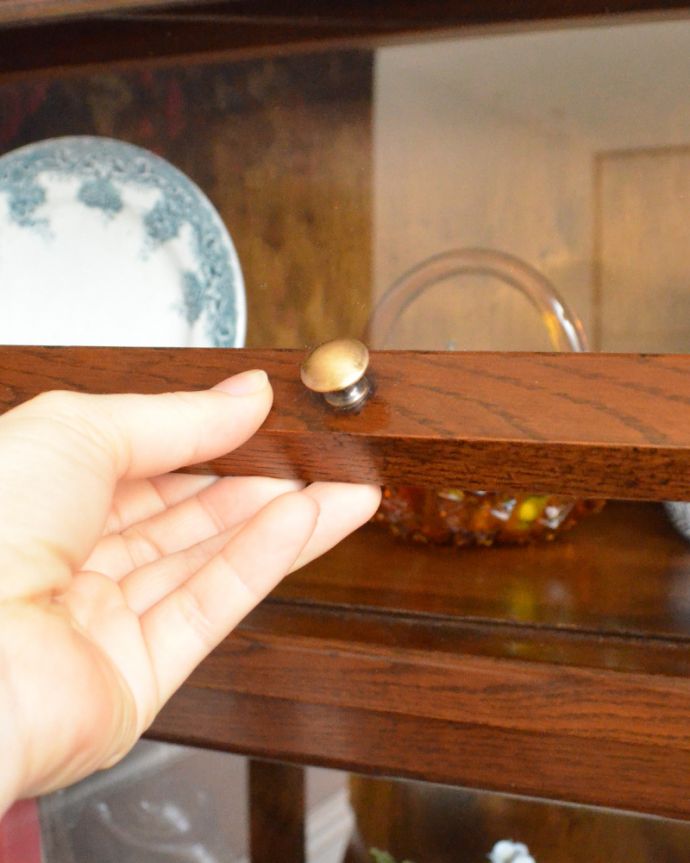 アンティークのキャビネット　アンティーク家具　葡萄の彫まで付いた美しい英国アンティーク家具、フラップ扉のブックケース（ガラスキャビネット）。扉の中央に真ん丸な取っ手が付いています。(q-866-f)