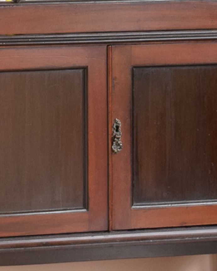 アンティークのキャビネット　アンティーク家具　素敵なアンティークの英国インテリア、シックなマホガニー材のガラスキャビネット（飾り棚）。凝った繊細な装飾が施された取っ手です。(q-924-f)