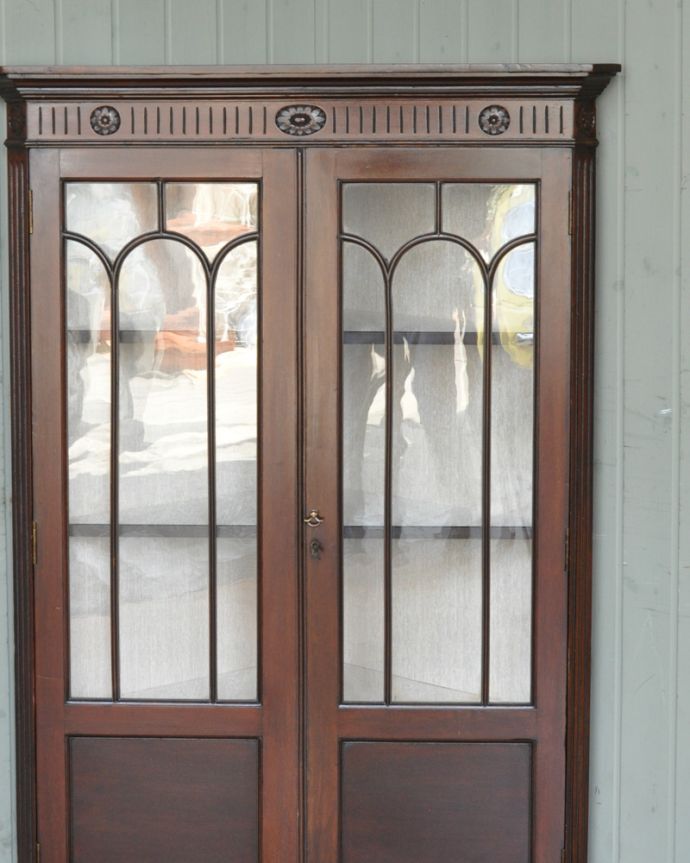 アンティークのキャビネット アンティーク家具 お花の彫刻が可愛いアンティークのコーナーガラスキャビネット(飾り棚) 。扉にはめ込まれたガラスもアンティークのもの。(q-929-f)