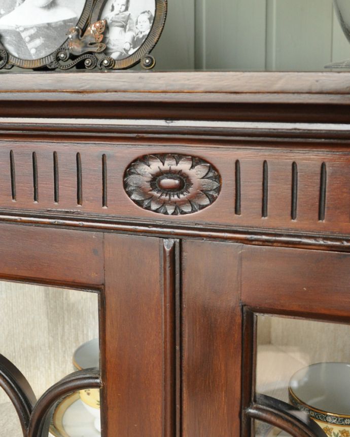 アンティークのキャビネット アンティーク家具 お花の彫刻が可愛いアンティークのコーナーガラスキャビネット(飾り棚) 。お花モチーフの木製の装飾が上品なアクセントになっています。(q-929-f)