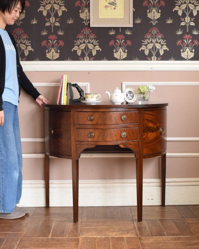 マホガニー材　アンティーク家具　英国輸入のアンティーク家具、ハーフムーンの美しいホールテーブル。お部屋の片隅に置いてあるだけでオシャレな空気に！（モデルの身長は160cmです）。(q-998-f)